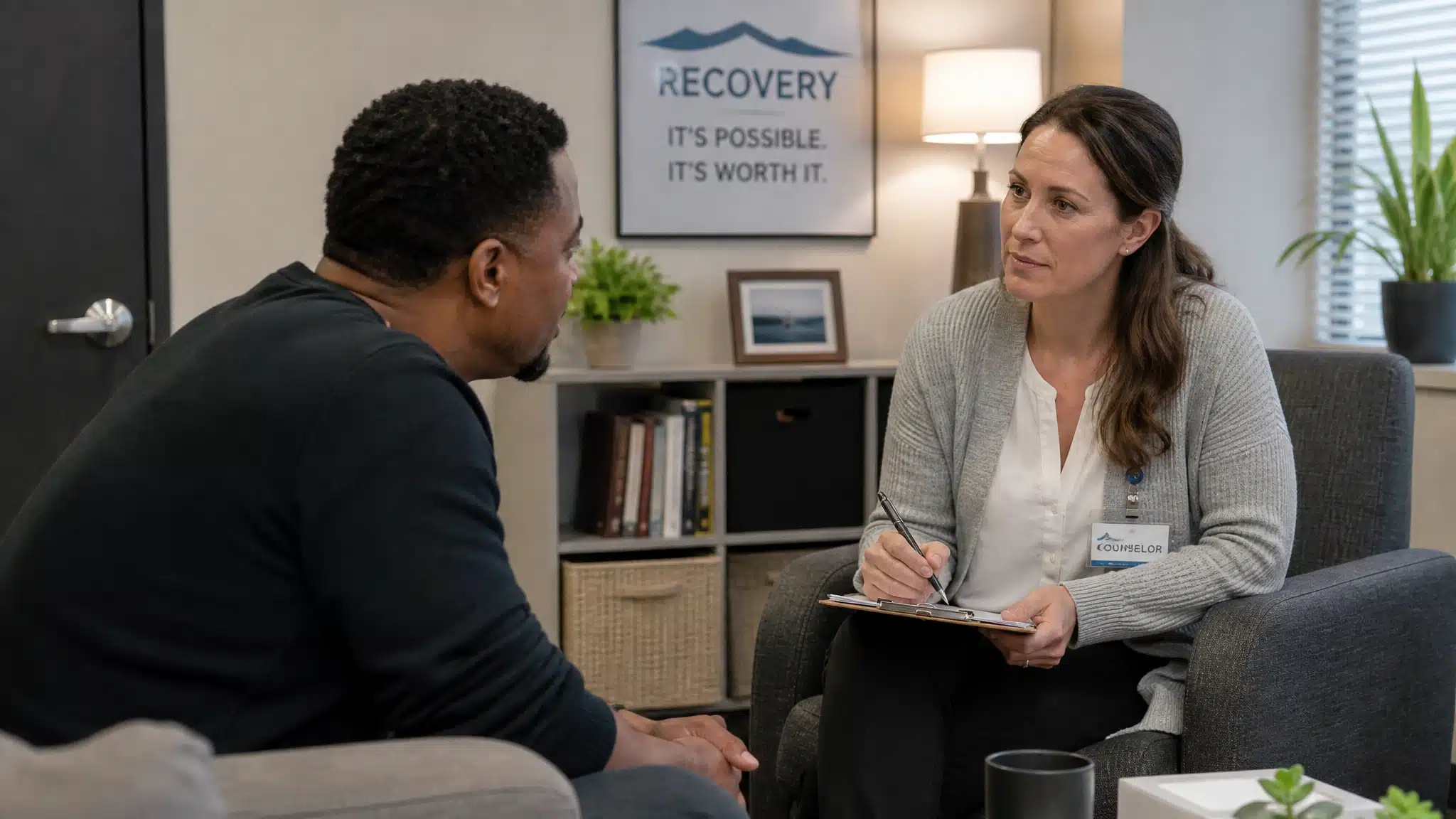 Adult speaking with a recovery counselor while reviewing a long-term treatment and aftercare plan, calm private setting, realistic healthcare photography.